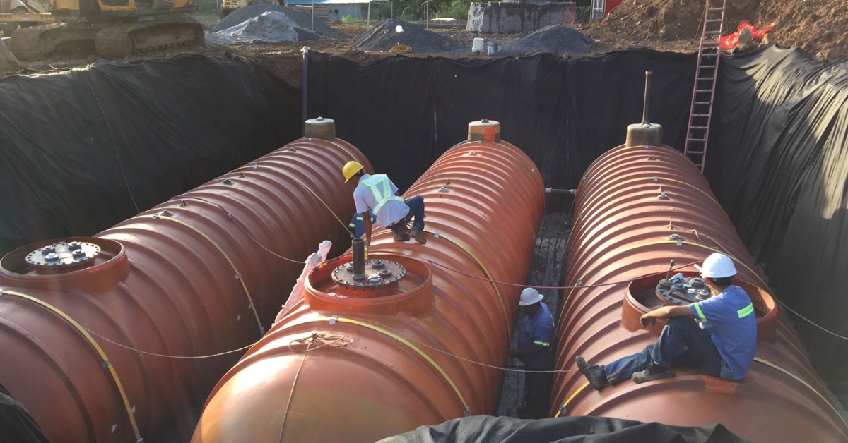 Dos técnicos de Master Services con casco durante la instalación de un tanque PLASTEEL en una estación de Panamá